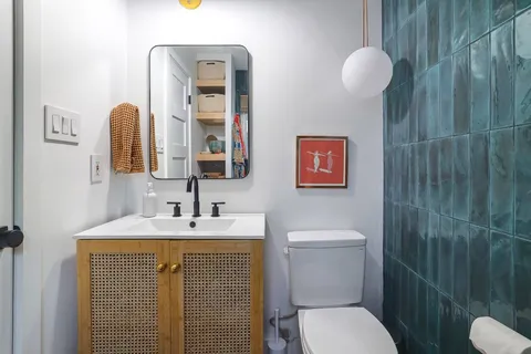 a bathroom with a toilet sink vanity and mirror