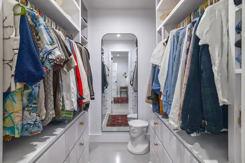 a view of walk in closet with clothes and shoes