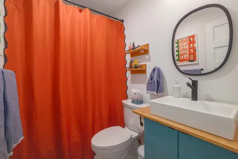 a bathroom with a toilet a sink and a mirror
