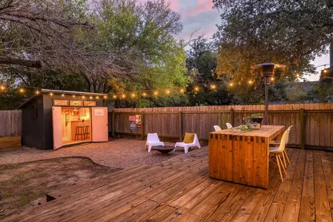 a view of a patio with table and chairs with wooden floor and fence