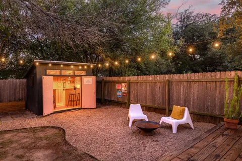 a view of a backyard with wooden fence and a bench
