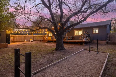 a view of a house with backyard and a tree