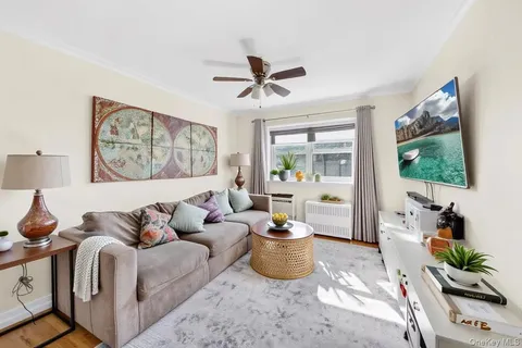 a living room with furniture a flat screen tv and a floor to ceiling window