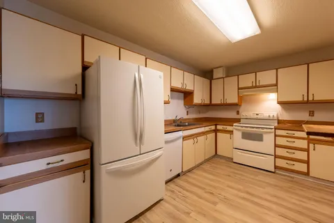 a kitchen with white cabinets and white appliances