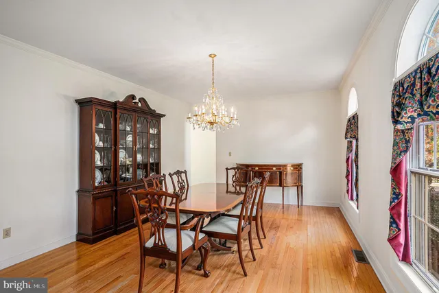 a view of a dining room with furniture a chandelier and wooden floor