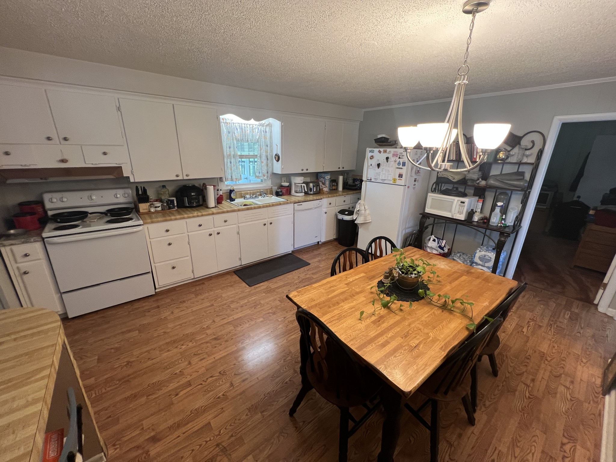 105 Tollgate Road Pulaski, TN 38478 - Photo 10 of 38 a kitchen with stainless steel appliances granite countertop a stove refrigerator a dining table and chairs with wooden floor