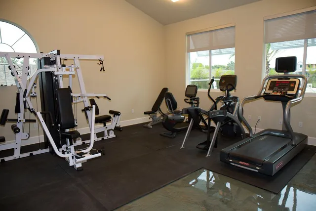 a room with gym equipment and windows