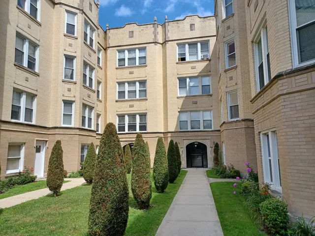 a front view of a residential apartment building with a yard