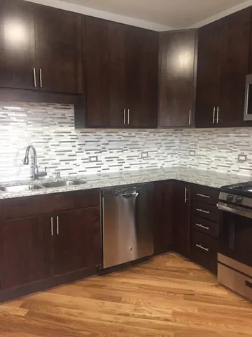 a kitchen with stainless steel appliances granite countertop a sink and a stove