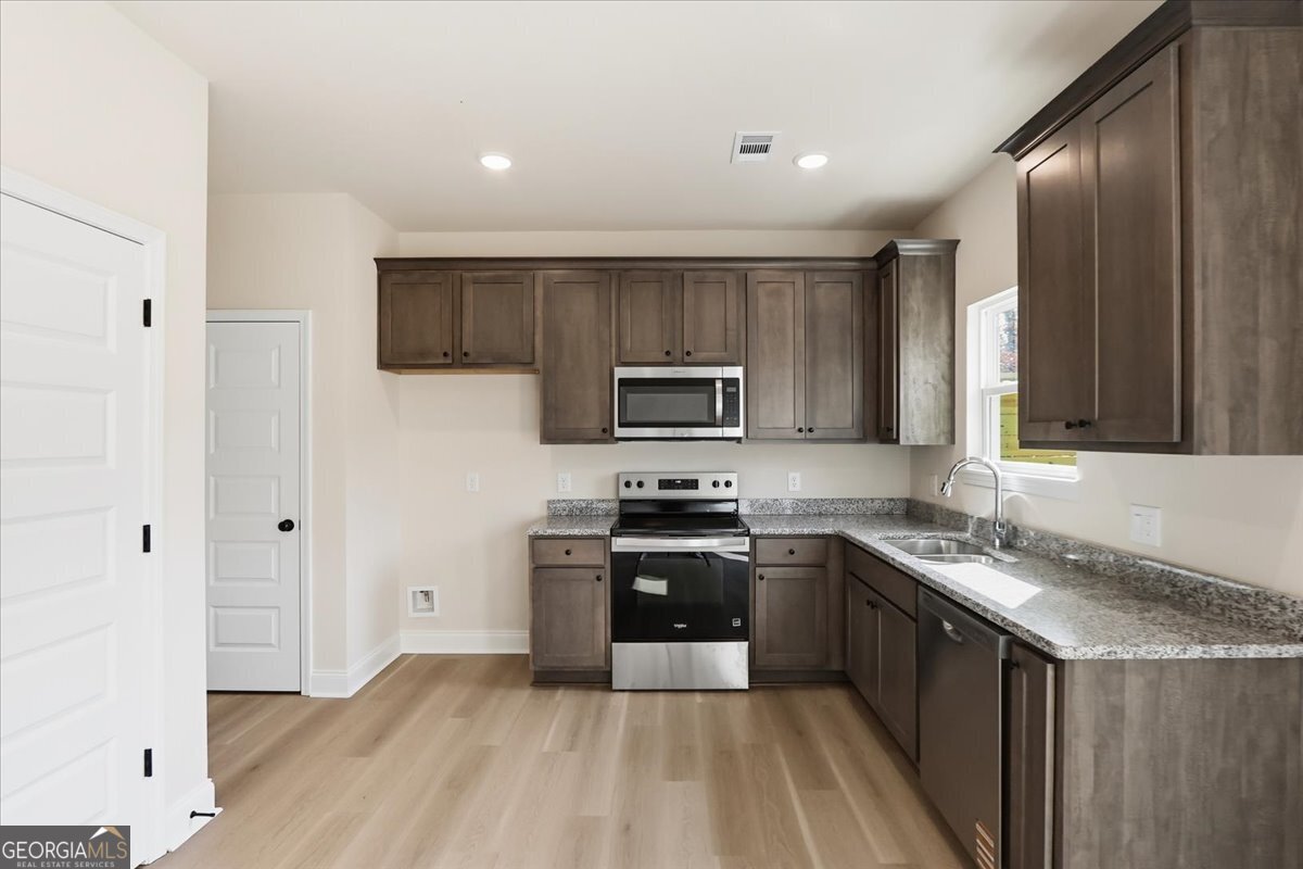 49 Wright Street, Unit 65 Lavonia, GA 30553 - Photo 11 of 57 a kitchen with stainless steel appliances granite countertop a stove a sink and a refrigerator