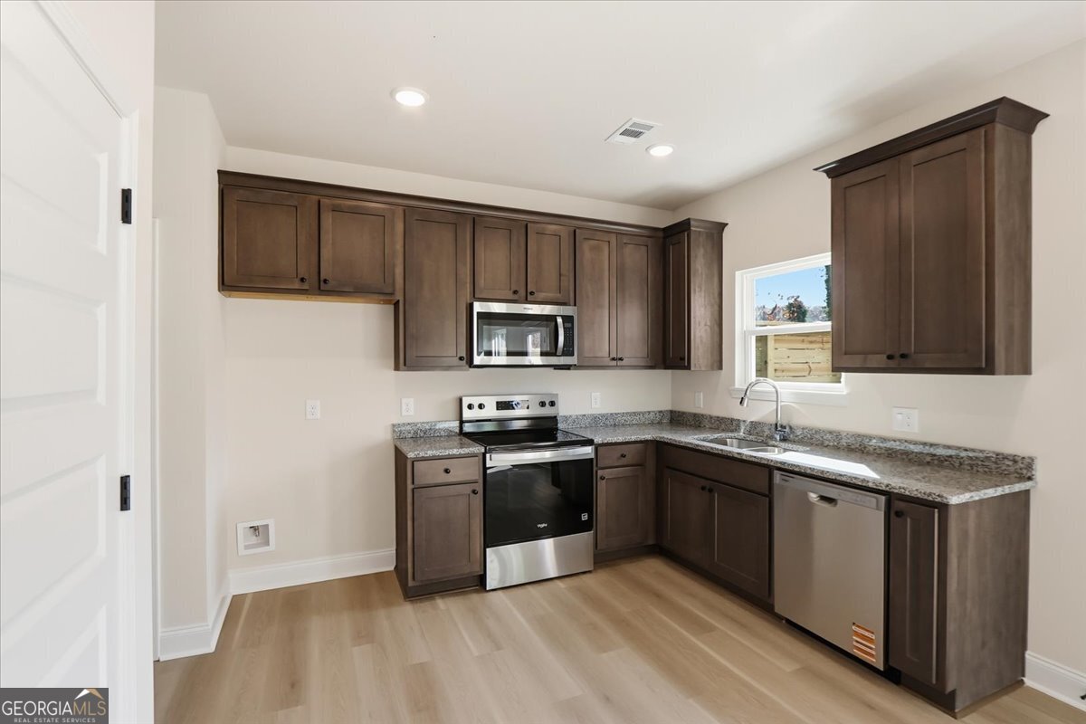 49 Wright Street, Unit 65 Lavonia, GA 30553 - Photo 12 of 57 a kitchen with stainless steel appliances granite countertop a sink stove and refrigerator