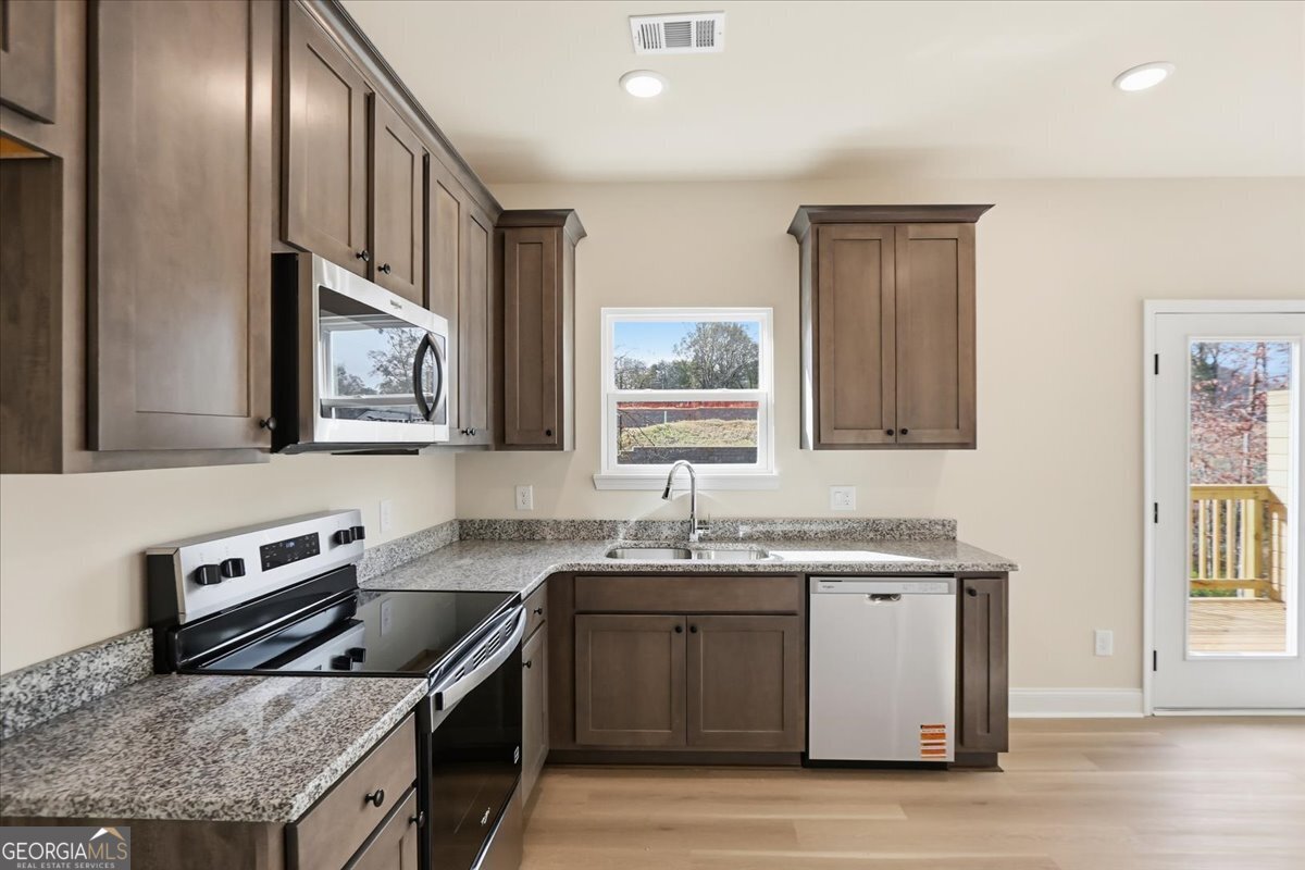 49 Wright Street, Unit 65 Lavonia, GA 30553 - Photo 14 of 57 a kitchen with stainless steel appliances granite countertop a sink stove and cabinets