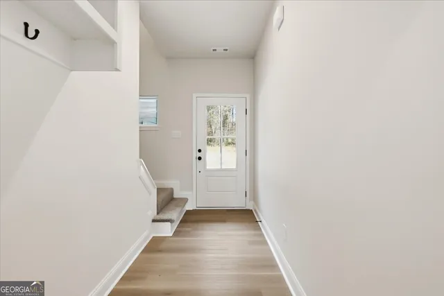 a view of a hallway with wooden floor