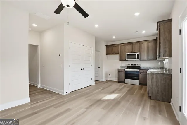 a kitchen with stainless steel appliances granite countertop a refrigerator a stove top oven a sink and dishwasher