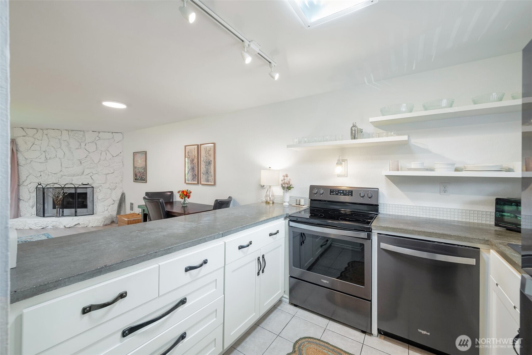 8017 196th Street Southwest, Unit 6B Edmonds, WA 98026 - Photo 11 of 23 a kitchen with granite countertop white cabinets stainless steel appliances and a counter space
