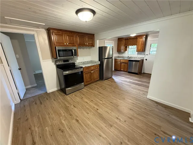 a large kitchen with stainless steel appliances granite countertop a stove and a refrigerator