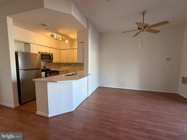 a kitchen with stainless steel appliances granite countertop a sink a refrigerator a stove and a refrigerator