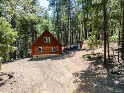 a view of a house with a yard and wooden fence