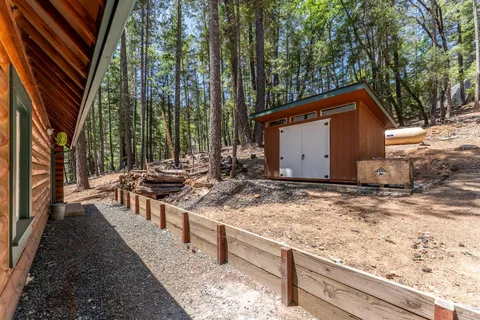 a wooden house with trees in the background