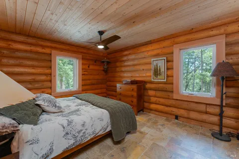 a bedroom with a bed and a dresser next to a window