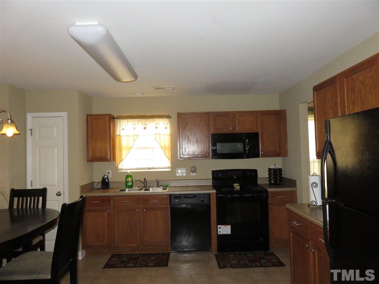 4124 Dalcross Road Raleigh, NC 27610 - Photo 2 of 14 a kitchen with granite countertop a refrigerator stove and microwave