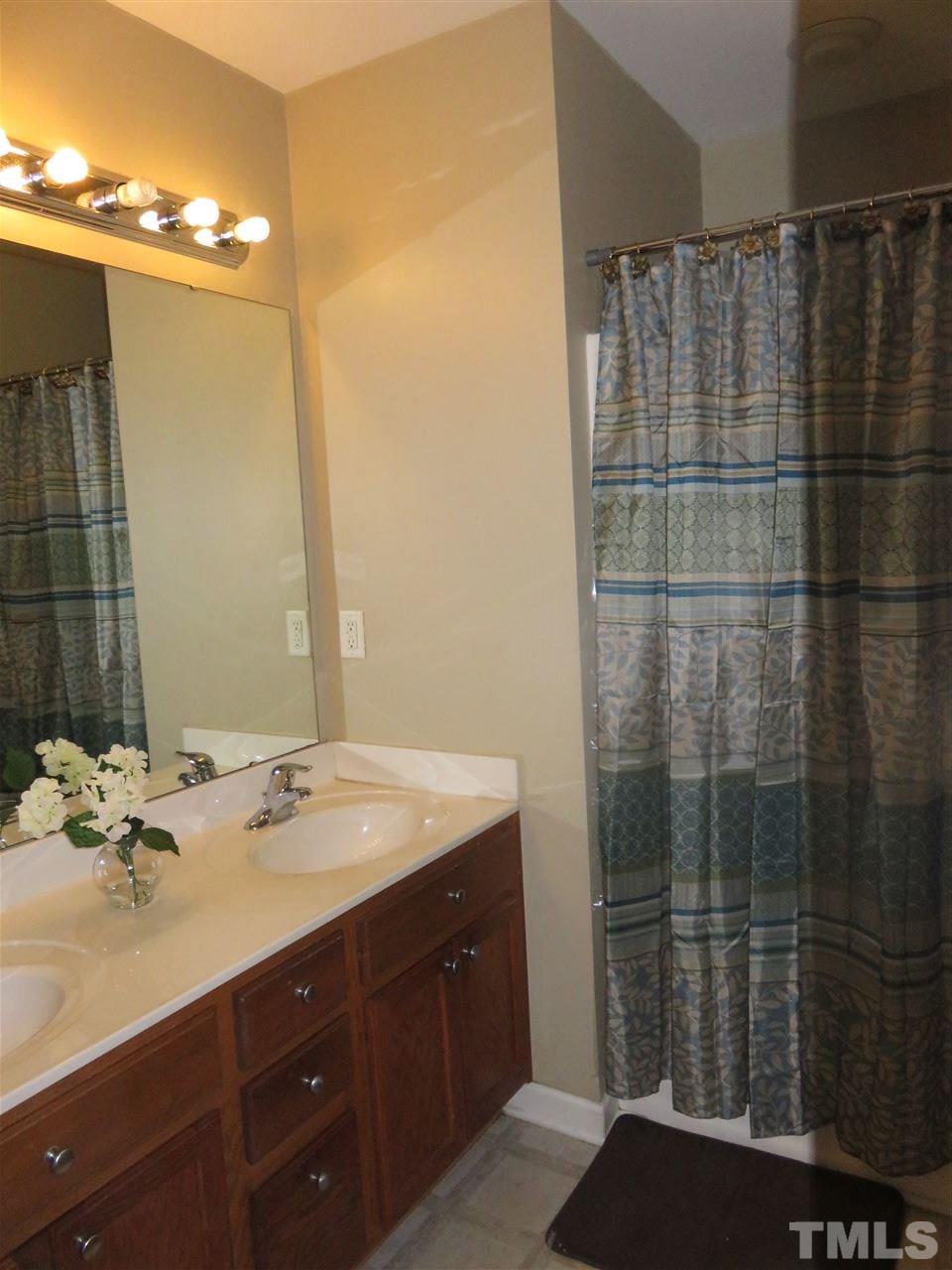 4124 Dalcross Road Raleigh, NC 27610 - Photo 11 of 14 a bathroom with a sink and a mirror
