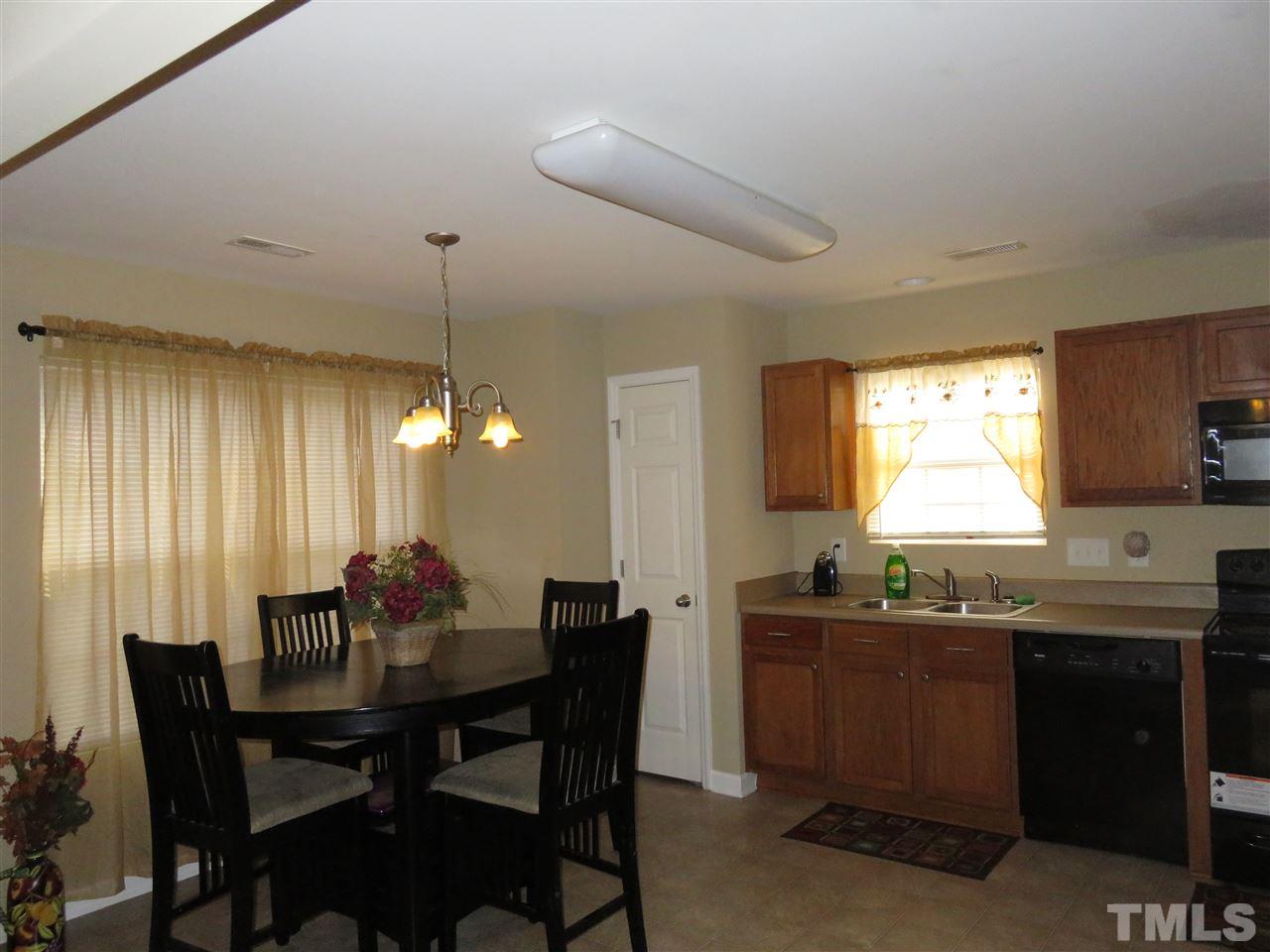 4124 Dalcross Road Raleigh, NC 27610 - Photo 4 of 14 a dining room with a table chairs and a kitchen view