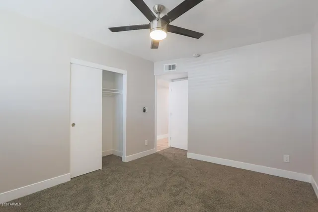 an empty room with a ceiling fan and a window