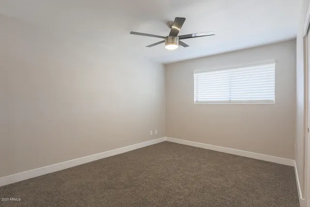a view of a livingroom with a ceiling fan and window