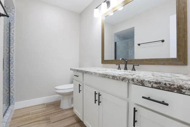 a bathroom with a granite countertop sink and a mirror
