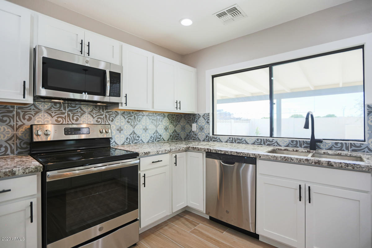 1817 East Alameda Drive Tempe, AZ 85282 - Photo 9 of 31 a kitchen with stainless steel appliances granite countertop a stove microwave and sink