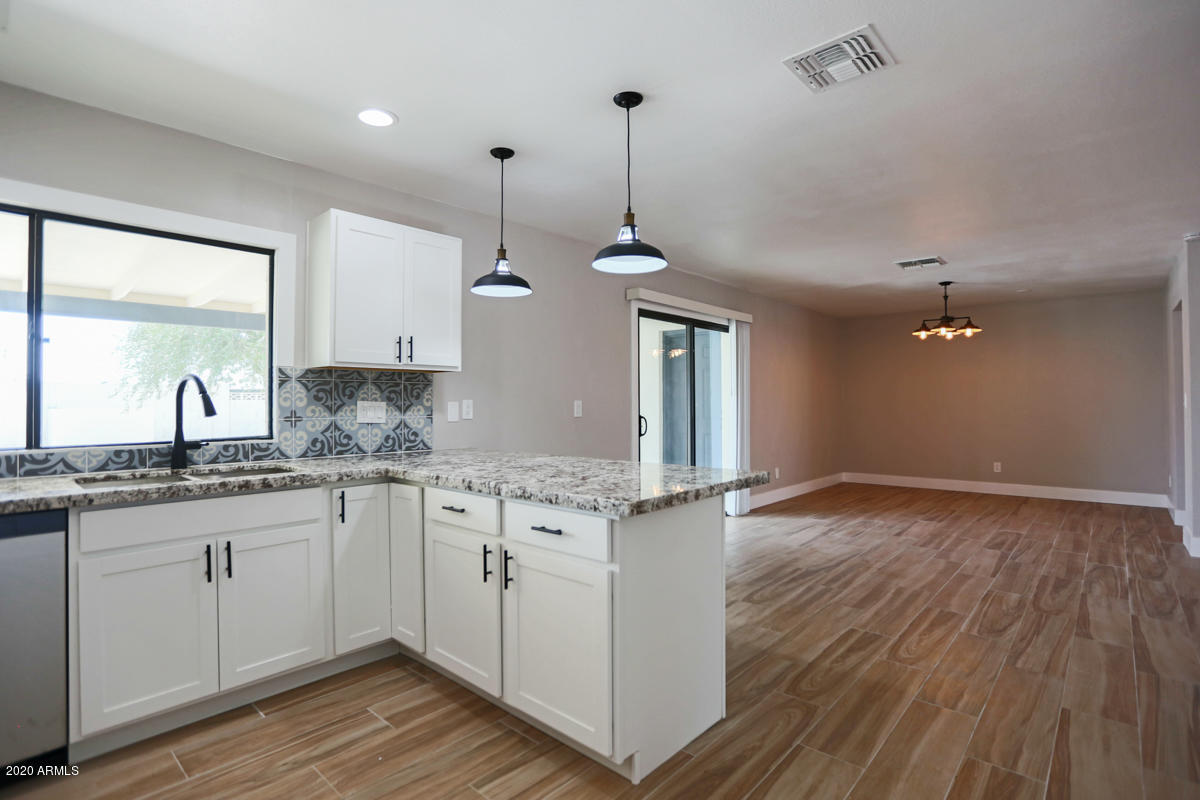 1817 East Alameda Drive Tempe, AZ 85282 - Photo 10 of 31 a kitchen with granite countertop a sink cabinets and wooden floor