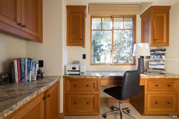 a kitchen with granite countertop a sink cabinets stainless steel appliances and a window