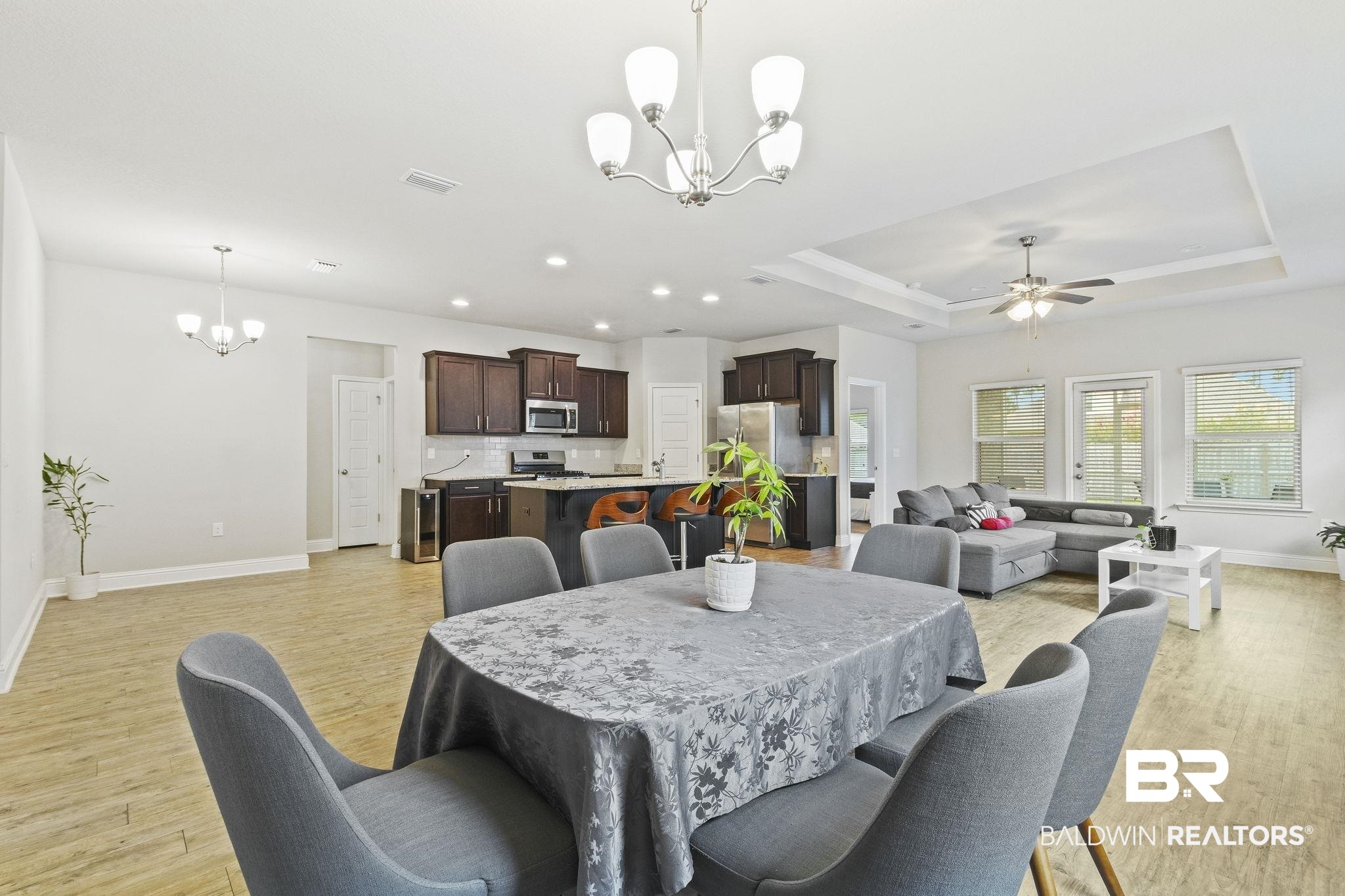 31643 Kestrel Loop Daphne, AL 36527 - Photo 18 of 59 Dining room featuring ceiling fan with notable chandelier, a raised ceiling, and light hardwood / wood-style floors