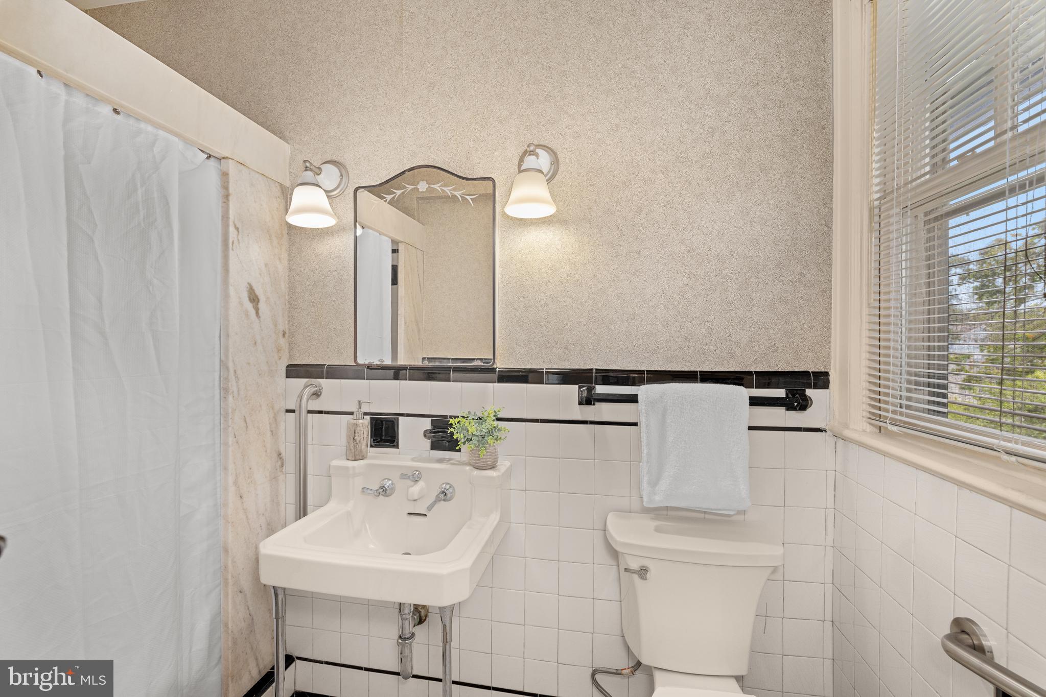 5410 39th Street Northwest Washington, DC 20015 - Photo 12 of 28 a bathroom with a sink a toilet and a mirror