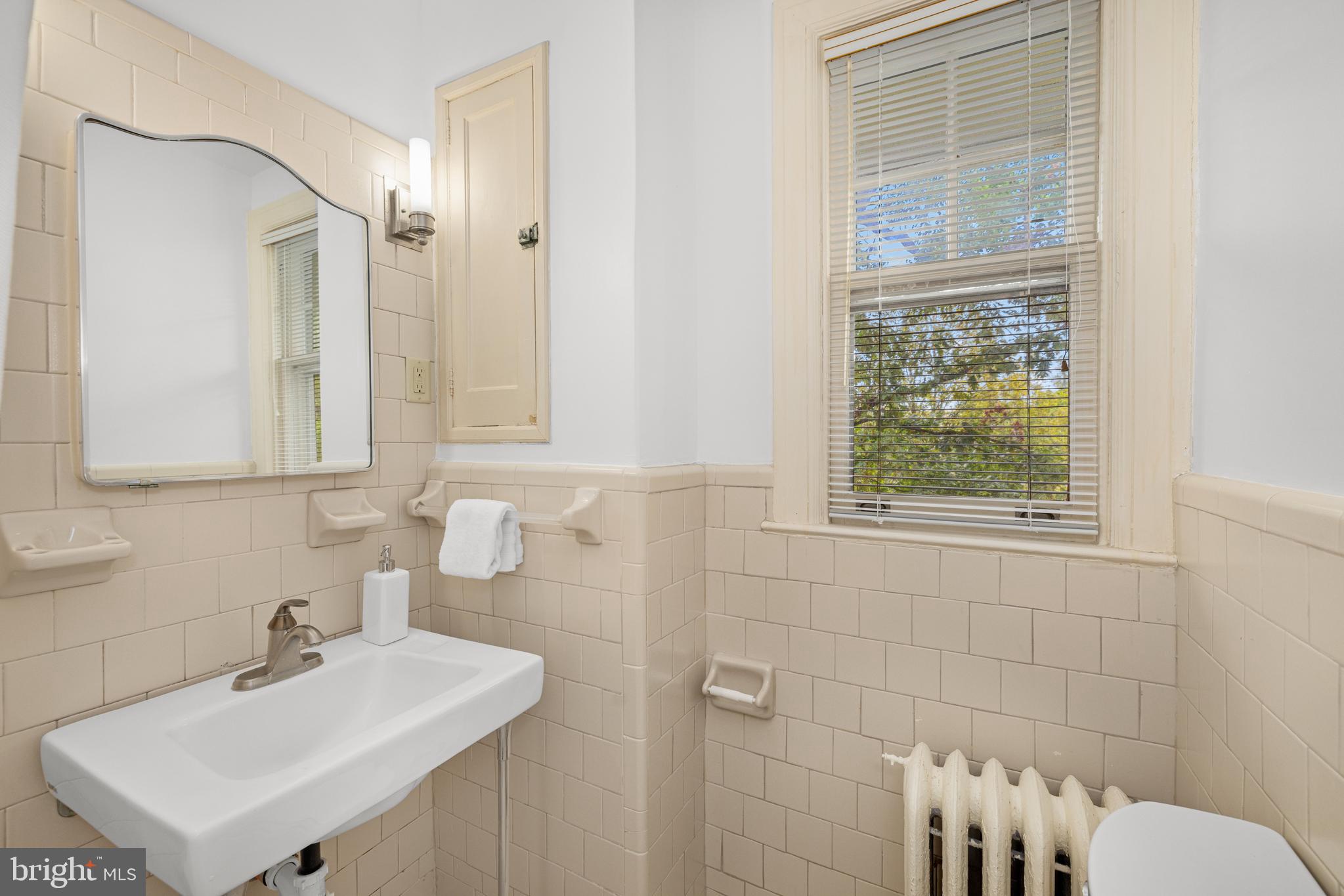 5410 39th Street Northwest Washington, DC 20015 - Photo 15 of 28 a bathroom with a sink a toilet and a mirror