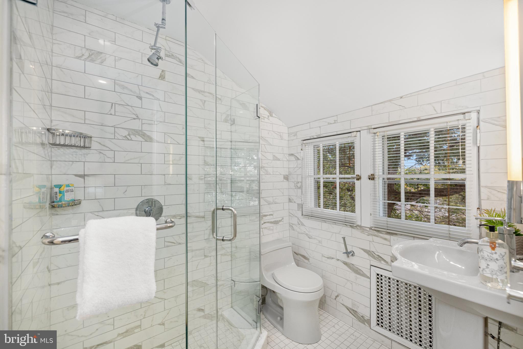 5410 39th Street Northwest Washington, DC 20015 - Photo 19 of 28 a bathroom with a granite countertop toilet a sink a shower and a mirror