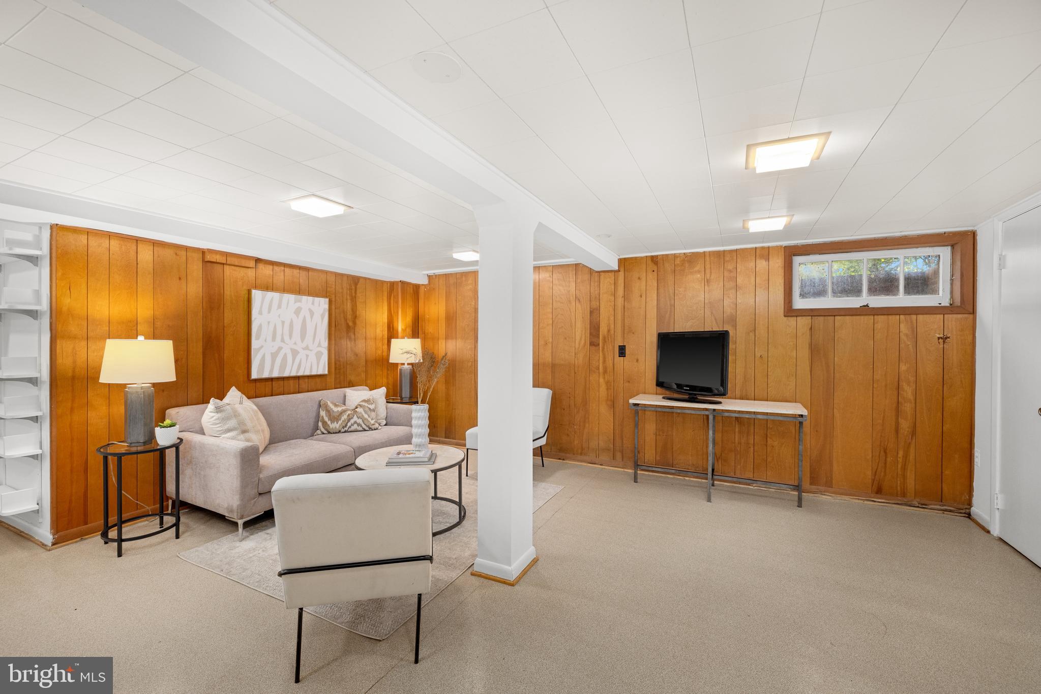 5410 39th Street Northwest Washington, DC 20015 - Photo 22 of 28 a living room with furniture a large window and a flat screen tv
