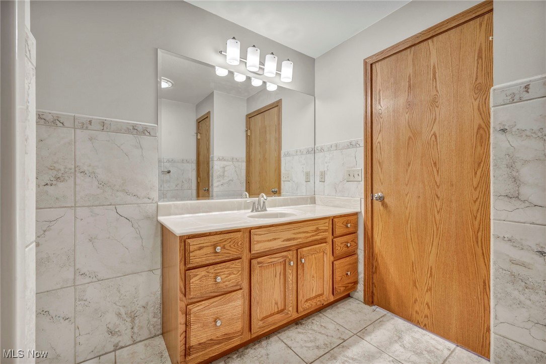 503 Churchill Road Youngstown, OH 44505 - Photo 8 of 32 Bathroom featuring tile walls, vanity, and wainscoting