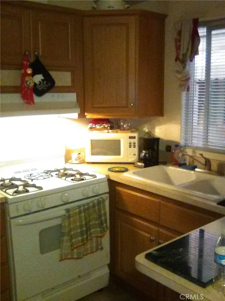 10799 Sherman Grove Avenue, Unit 18 Sunland, CA 91040 - Photo 4 of 7 a kitchen with a stove and a sink