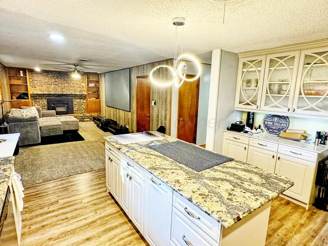 a large bedroom with kitchen island stainless steel appliances a stove a sink dishwasher and cabinets with wooden floor