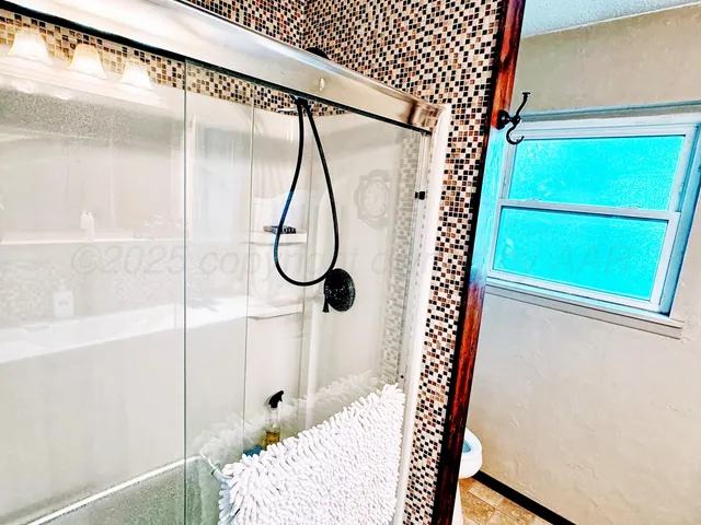 a bathroom with a glass shower door