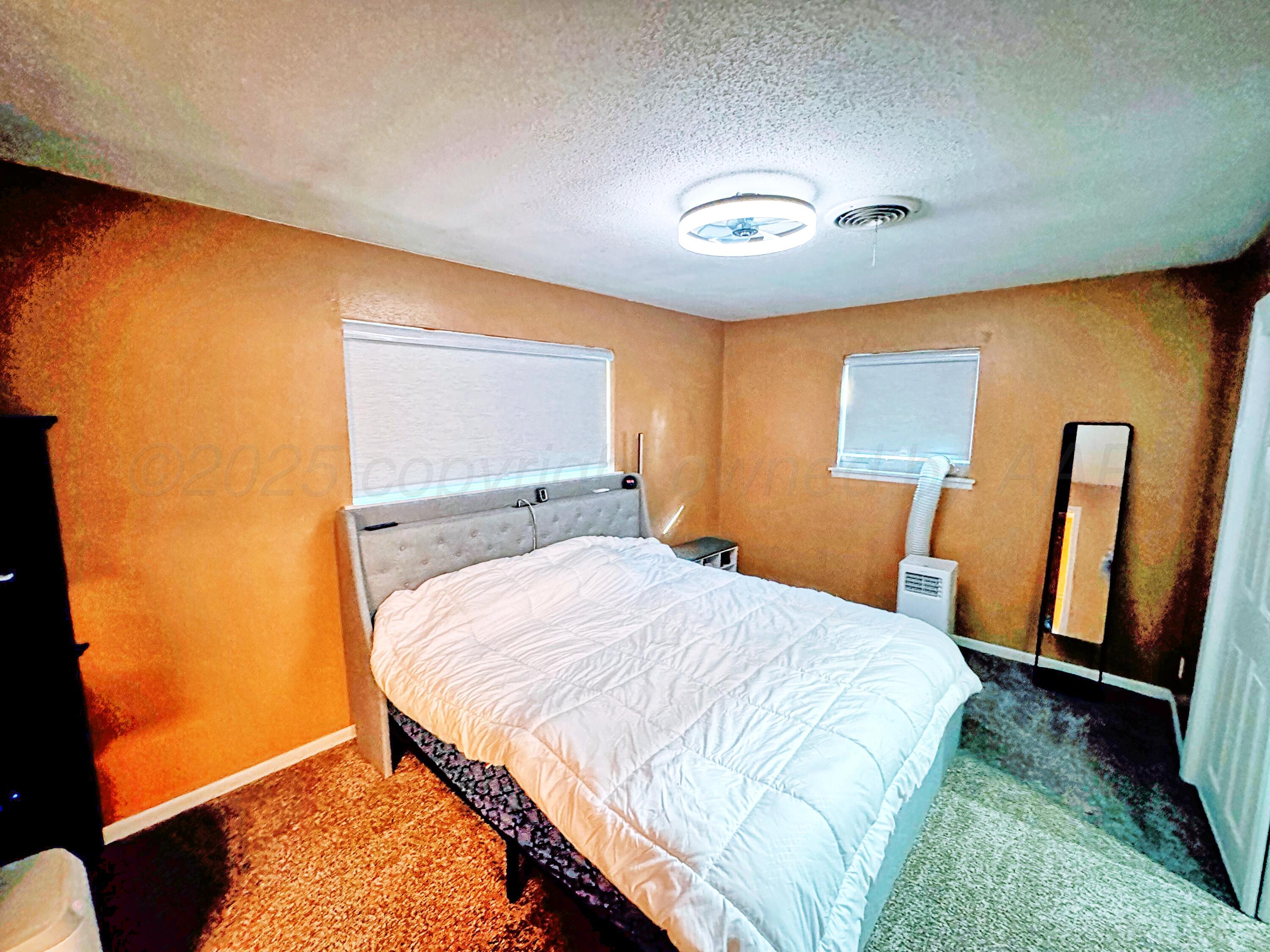 3210 South Ash Street Perryton, TX 79070 - Photo 16 of 28 a bedroom with a bed and wooden floor