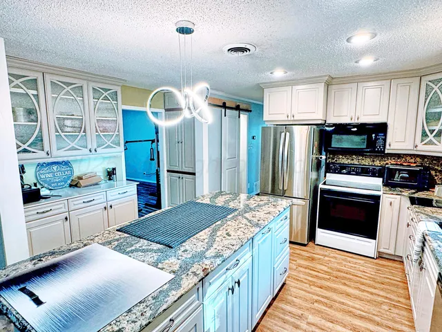 a kitchen with stainless steel appliances granite countertop a stove refrigerator and cabinets