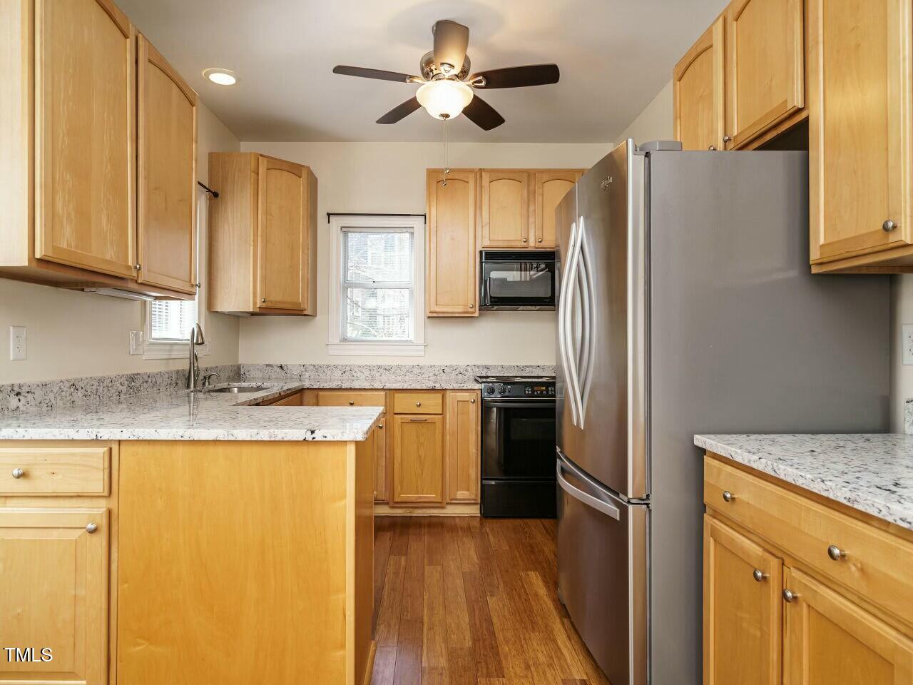 5917 Sentinel Drive Raleigh, NC 27609 - Photo 14 of 32 a kitchen with stainless steel appliances granite countertop a refrigerator a sink dishwasher a stove and white countertops with wooden floor