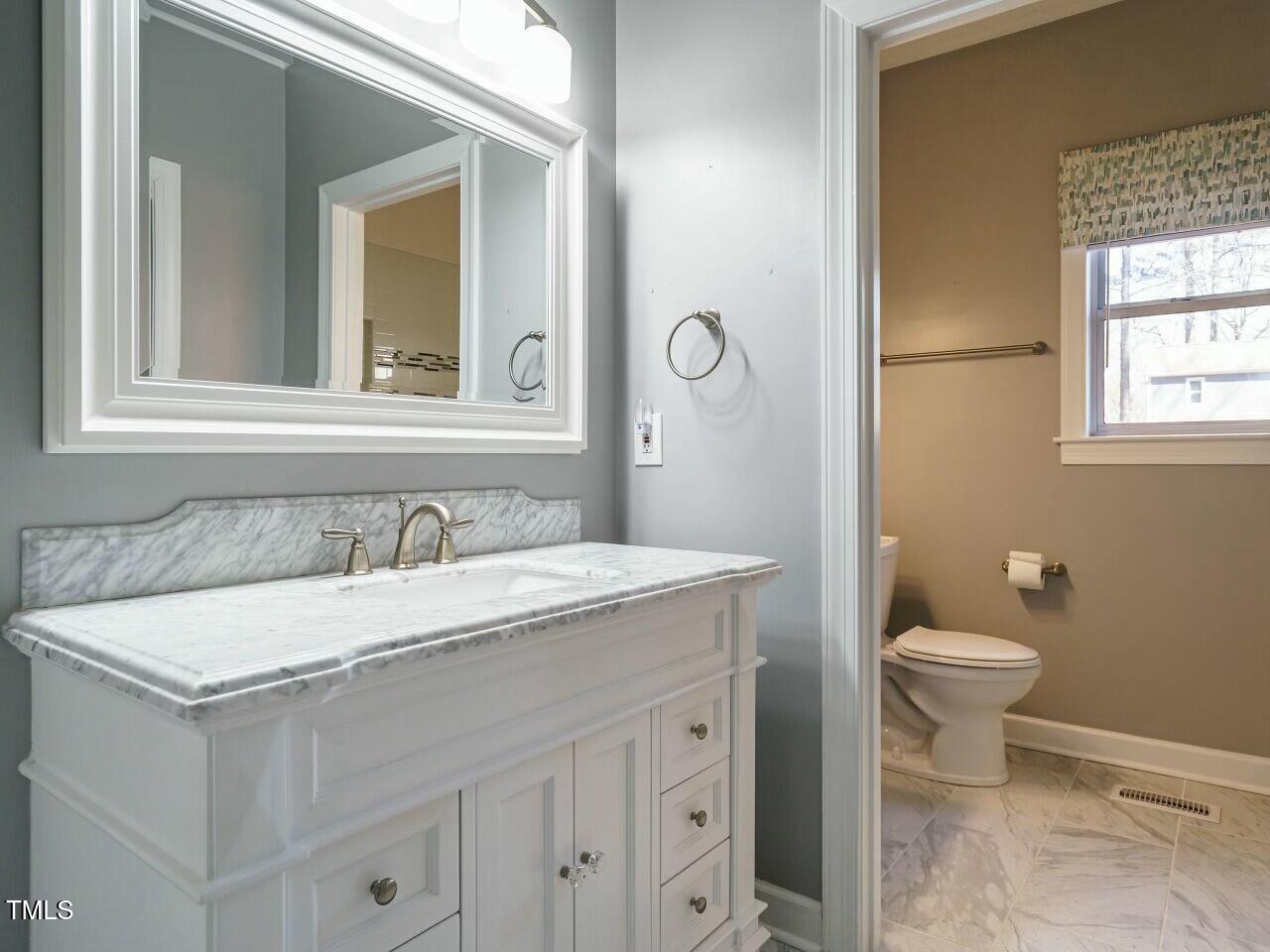 5917 Sentinel Drive Raleigh, NC 27609 - Photo 22 of 32 a bathroom with a granite countertop sink toilet and mirror