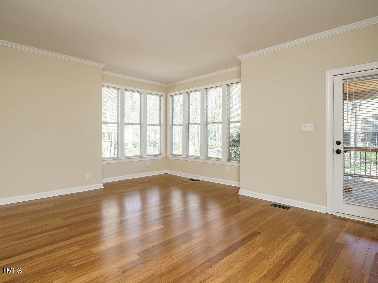 5917 Sentinel Drive Raleigh, NC 27609 - Photo 7 of 32 a view of an empty room with wooden floor and a window