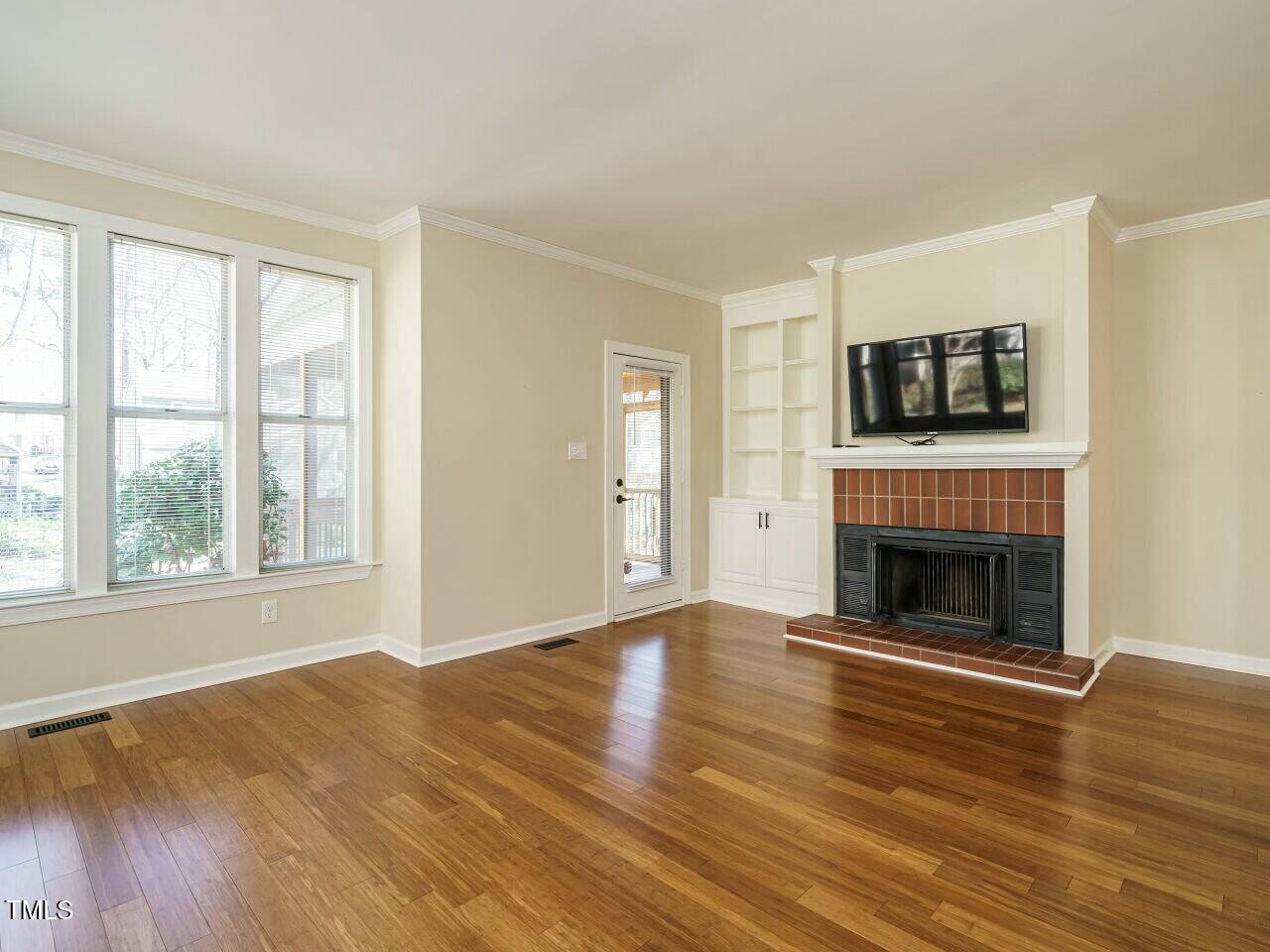 5917 Sentinel Drive Raleigh, NC 27609 - Photo 8 of 32 a view of an empty room with wooden floor fireplace and a window