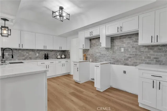 a kitchen with cabinets appliances a sink and a counter top
