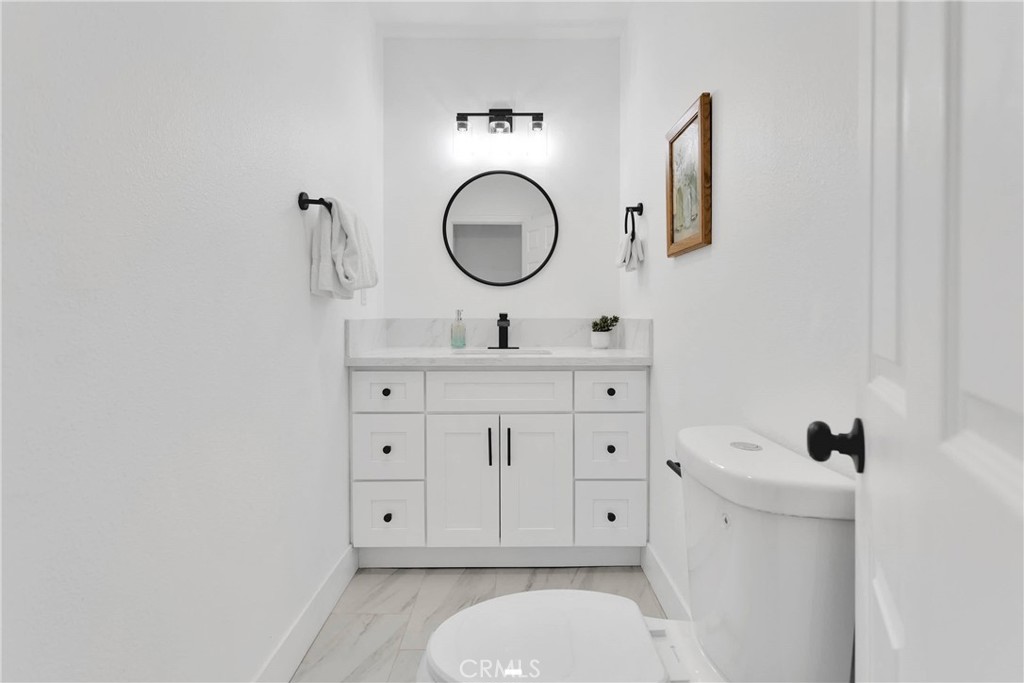 3489 Circle Road San Bernardino, CA 92405 - Photo 23 of 51 a bathroom with a toilet a sink and mirror